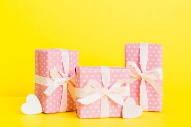 gift box with red bow and red heart on colored background. Perspective view. Flat lay.