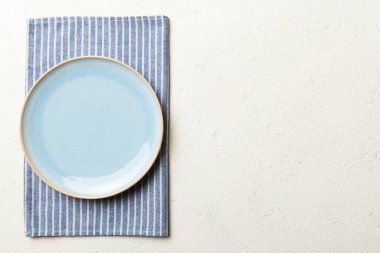 Renkli arkaplanda üst görünüm yiyecek için mavi tabak üzerinde boş. Tasarımınız için boşluk olan peçeteye boş tabak.