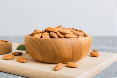 Fresh healthy Almond in bowl on colored table background. Top view.