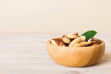 Fresh healthy Brazil nuts in bowl on colored table background. Top view Healthy eating bertholletia concept. Super foods.