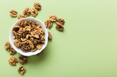 Fresh healthy walnuts in bowl on colored table background. Top view Healthy eating bertholletia concept. Super foods.