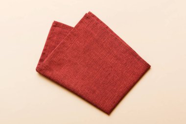 top view with red empty kitchen napkin isolated on table background. Folded cloth for mockup with copy space, Flat lay. Minimal style.