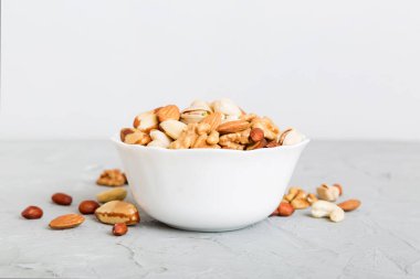 mixed nuts in bowl. Mix of various nuts on colored background. pistachios, cashews, walnuts, hazelnuts, peanuts and brazil nuts.
