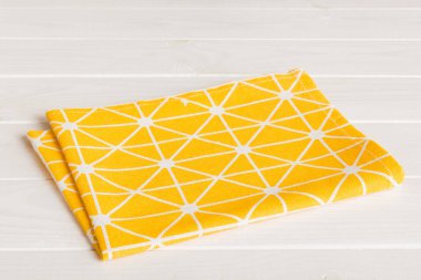 top view with yellow empty kitchen napkin isolated on table background. Folded cloth for mockup with copy space, Flat lay. Minimal style.