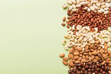 different nuts frame background. Close up, top view, flat lay with vopy space. Walnut, pistachios, almonds, hazelnuts and cashews.
