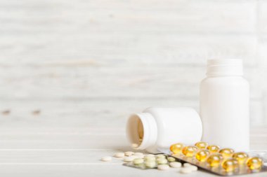 Medicine for treatment HIV infection. Pills and capsules and battle on the table. Different colorful tablets at colored background with copy space.