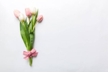 Renkli masa arkasında bir buket pembe lale. Kopyalama alanı olan üst görünüm. Baharı bekliyorum. Mutlu Paskalyalar. Düz yatıyordu.