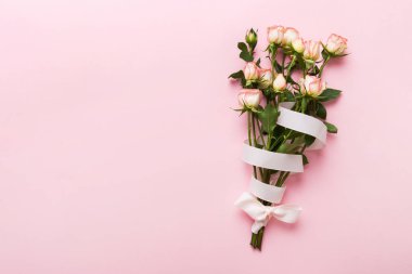 Renkli arka planda pembe buket ve beyaz güller. Anneler günü, sevgililer günü, doğum günü kutlaması konsepti. Tebrik kartı. Metin için boşluk kopyala, üst görünüm.