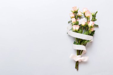 Renkli arka planda pembe buket ve beyaz güller. Anneler günü, sevgililer günü, doğum günü kutlaması konsepti. Tebrik kartı. Metin için boşluk kopyala, üst görünüm.