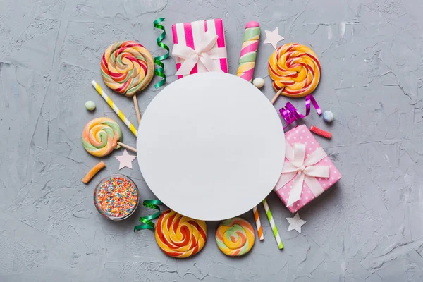 stock image Flat lay holiday composition. Paper blank, lollipop, birthday decorations on Colored background. Top view, copy space for text.