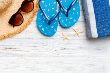 Yaz tatili konsepti düzdü. Hasır şapka plaj aksesuarları ve havlunun üstü. Mesaj için yer var. seyahat kavramı.