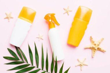 Güneş kremi şişesi. Güneş korumalı krem ve tropik yeşil yapraklı deniz kabukları olan bir şişe..