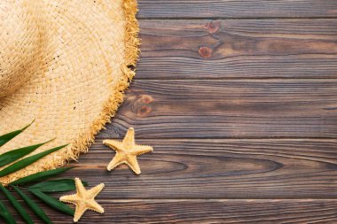 Summer holidays. Summer concept with straw hat and tropical leaf. Flat lay, top view, copy space.