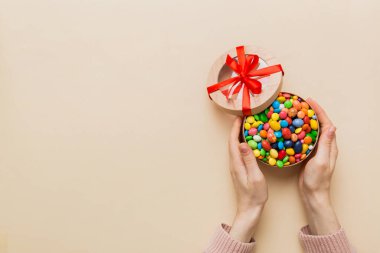 Renkli kutuda lezzetli şekerlemeleri olan kadın elleri.