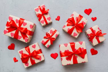 Top view photo of valentine day decorations gift box with red ribbon bow on colored background. Holiday gift boxes with top view.