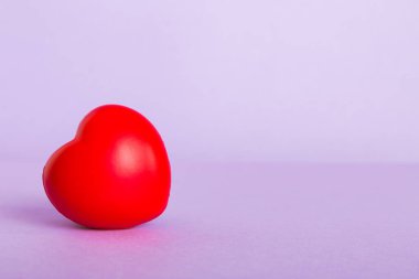 gift box with red bow and red heart on colored background. Perspective view. Flat lay.