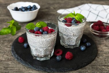 Sağlıklı kahvaltı ya da sabah chia tohumlu vanilyalı puding ahududu ve böğürtlen, vejetaryen gıda, diyet ve sağlık konsepti. Ahududu ve yabanmersinli Chia pudingi..