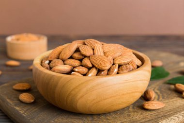 Fresh healthy Almond in bowl on colored table background. Top view.