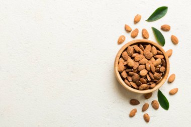 Fresh healthy Almond in bowl on colored table background. Top view.