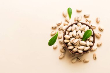 Fresh healthy Pistachios in bowl on colored table background. Top view. Healthy eating concept. Super foods.