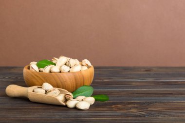 Fresh healthy Pistachios in bowl on colored table background. Top view. Healthy eating concept. Super foods.