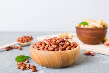 Fresh healthy peanuts in bowl on colored table background. Top view Healthy eating bertholletia concept. Super foods.