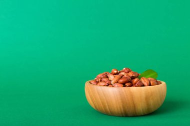 Fresh healthy peanuts in bowl on colored table background. Top view Healthy eating bertholletia concept. Super foods.