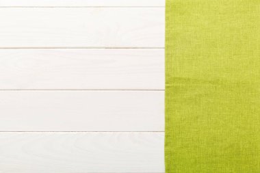 top view with green kitchen napkin isolated on table background. Folded cloth for mockup with copy space, Flat lay. Minimal style.