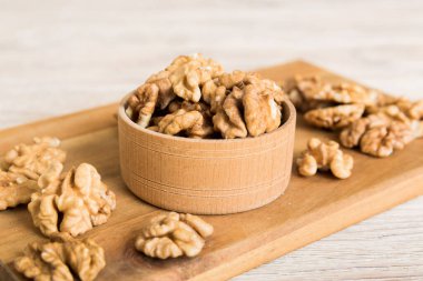 Fresh healthy walnuts in bowl on colored table background. Top view Healthy eating bertholletia concept. Super foods.