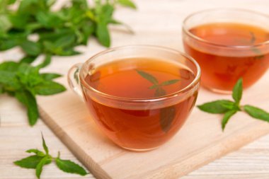 Arka planda bir fincan nane çayı. Fotokopi alanı ile taze nane görünümlü yeşil çay.