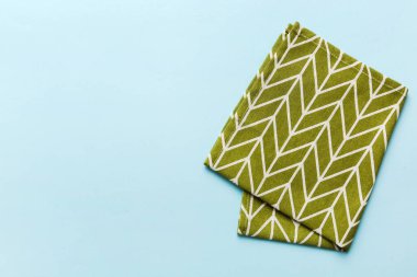 top view with green kitchen napkin isolated on table background. Folded cloth for mockup with copy space, Flat lay. Minimal style.