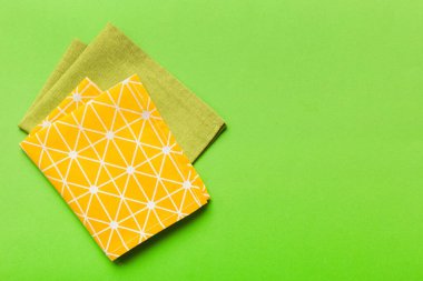 top view with yellow empty kitchen napkin isolated on table background. Folded cloth for mockup with copy space, Flat lay. Minimal style.