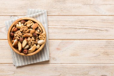 mixed nuts in bowl. Mix of various nuts on colored background. pistachios, cashews, walnuts, hazelnuts, peanuts and brazil nuts.