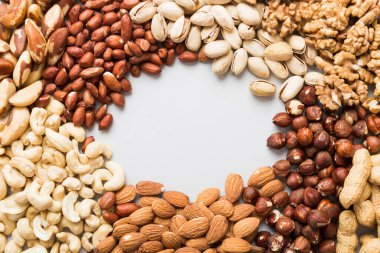 different nuts frame background. Close up, top view, flat lay with vopy space. Walnut, pistachios, almonds, hazelnuts and cashews.