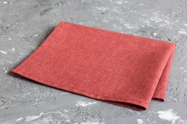 top view with red empty kitchen napkin isolated on table background. Folded cloth for mockup with copy space, Flat lay. Minimal style.