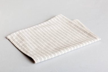 top view with gray kitchen napkin isolated on table background. Folded cloth for mockup with copy space, Flat lay. Minimal style.
