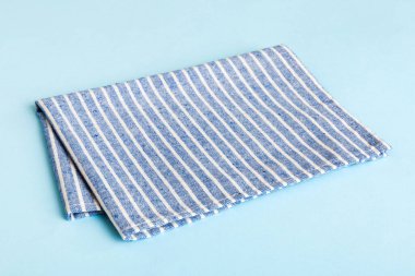 top view with blue kitchen napkin isolated on table background. Folded cloth for mockup with copy space, Flat lay. Minimal style.