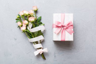 Pembe gül çiçekli tasarım konsepti ve renkli masa arkası manzaralı hediye kutusu. Mutlu Noeller, Anneler Günü, doğum günü konsepti. Romantik düz konum.