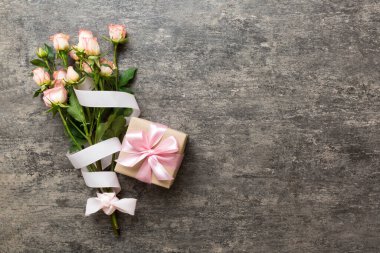 Pembe gül çiçekli tasarım konsepti ve renkli masa arkası manzaralı hediye kutusu. Mutlu Noeller, Anneler Günü, doğum günü konsepti. Romantik düz konum.