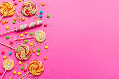 Lezzetli İştah açıcı Parti Aksesuarları Mutlu Yıllar Tatlı. Renkli arkaplanda farklı tipte şekerler, kopyalama alanı. Renkli doğum günü partisi geçmişi.