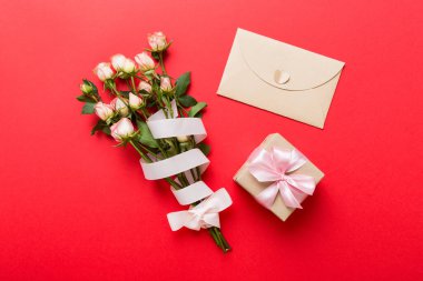 Renkli masa arkasında pembe kurdele ve gül çiçekleri olan tebrik kartı modeli. Düz yerde, üst tarafta. Anneler günü tatil konsepti.