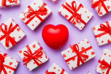 gift box with red bow and red heart on colored background . Top view. Flat lay.