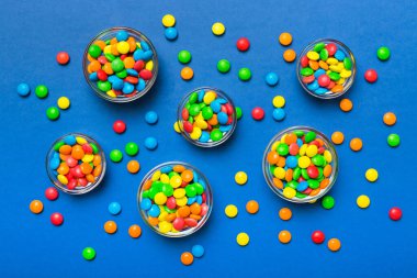 farklı renkte yuvarlak şekerler ve kavanozlar. Fotokopi alanı olan büyük çeşitlilikteki şeker ve şekerlerin üst görünümü.