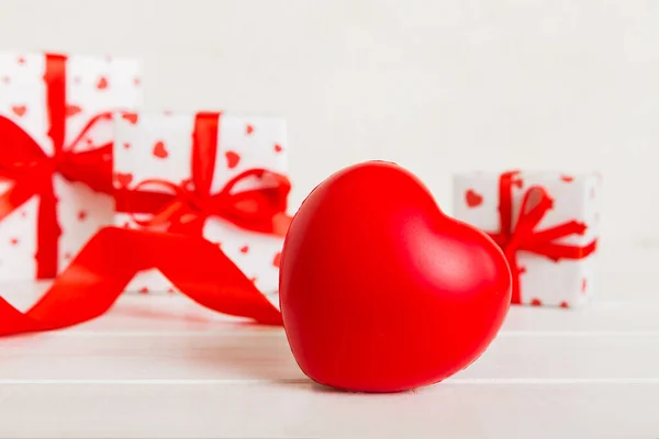 stock image gift box with red bow and red heart on colored background. Perspective view. Flat lay.