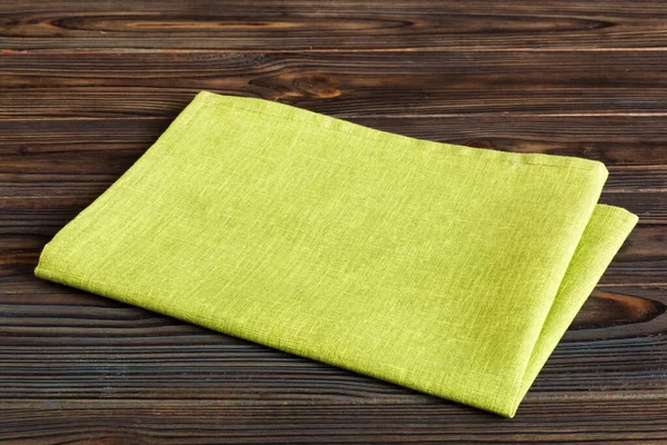 top view with green kitchen napkin isolated on table background. Folded cloth for mockup with copy space, Flat lay. Minimal style.