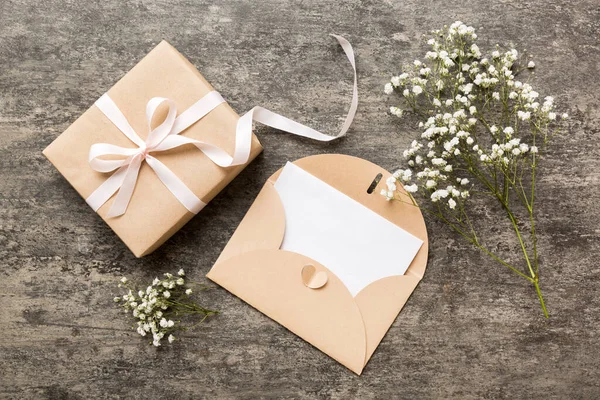 stock image Wedding mockup with white paper list and flowers gypsophila on colored table top view flat lay. Blank greeting cards and envelopes. Beautiful floral pattern. Flat lay style.