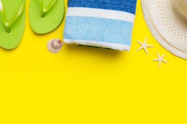 Yaz tatili konsepti düzdü. Hasır şapka plaj aksesuarları ve havlunun üstü. Mesaj için yer var. seyahat kavramı.