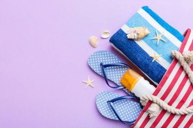 beach accessories flat lay top view on colored background Summer travel concept. Bag with starfish and sea shell. Top view.