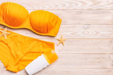 Kadın mayo ve plaj aksesuarları renkli arka plan yaz seyahati konseptine düz bir görünüm kazandırıyordu. Bikini mayo, hasır şapka ve deniz topuklu ayakkabı. Üst görünümü kopyala.