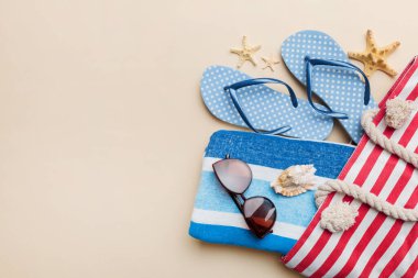 Plaj aksesuarları renkli arka plan yaz seyahati konseptinde düz bir görünüm sergiliyordu. İçinde deniz yıldızı ve deniz kabuğu olan bir çanta. Üst görünüm.